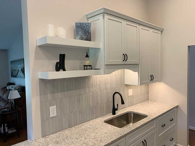 A traditional kitchen with oak cabinets, granite countertops, and a farmhouse-style sink. The room is filled with warm, soft lighting, creating a welcoming ambiance.
