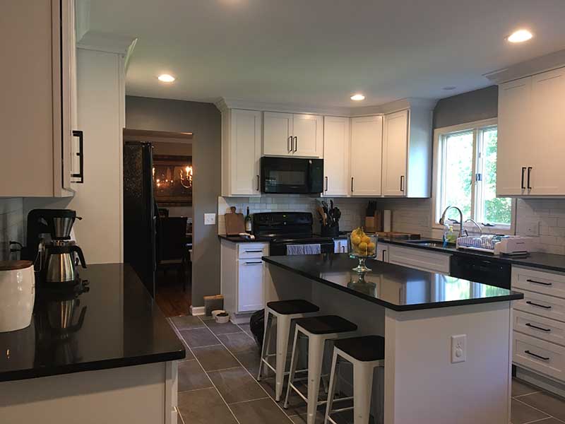 A contemporary kitchen with a fresh design, boasting glossy gray cabinets, quartz countertops, and a chic mosaic tile backsplash.