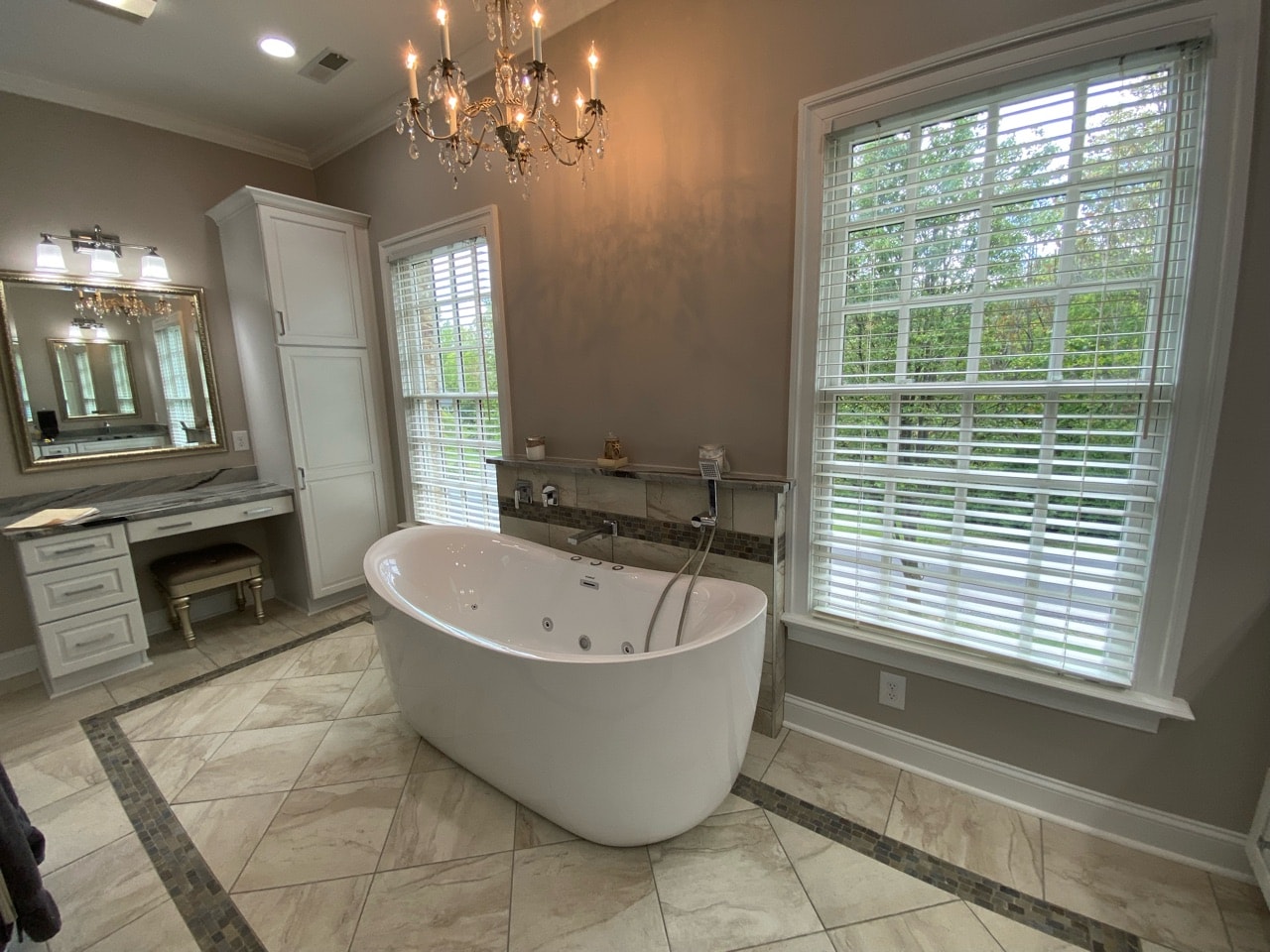 A recently renovated bathroom featuring mosaic tile accents and a freestanding soaking tub.