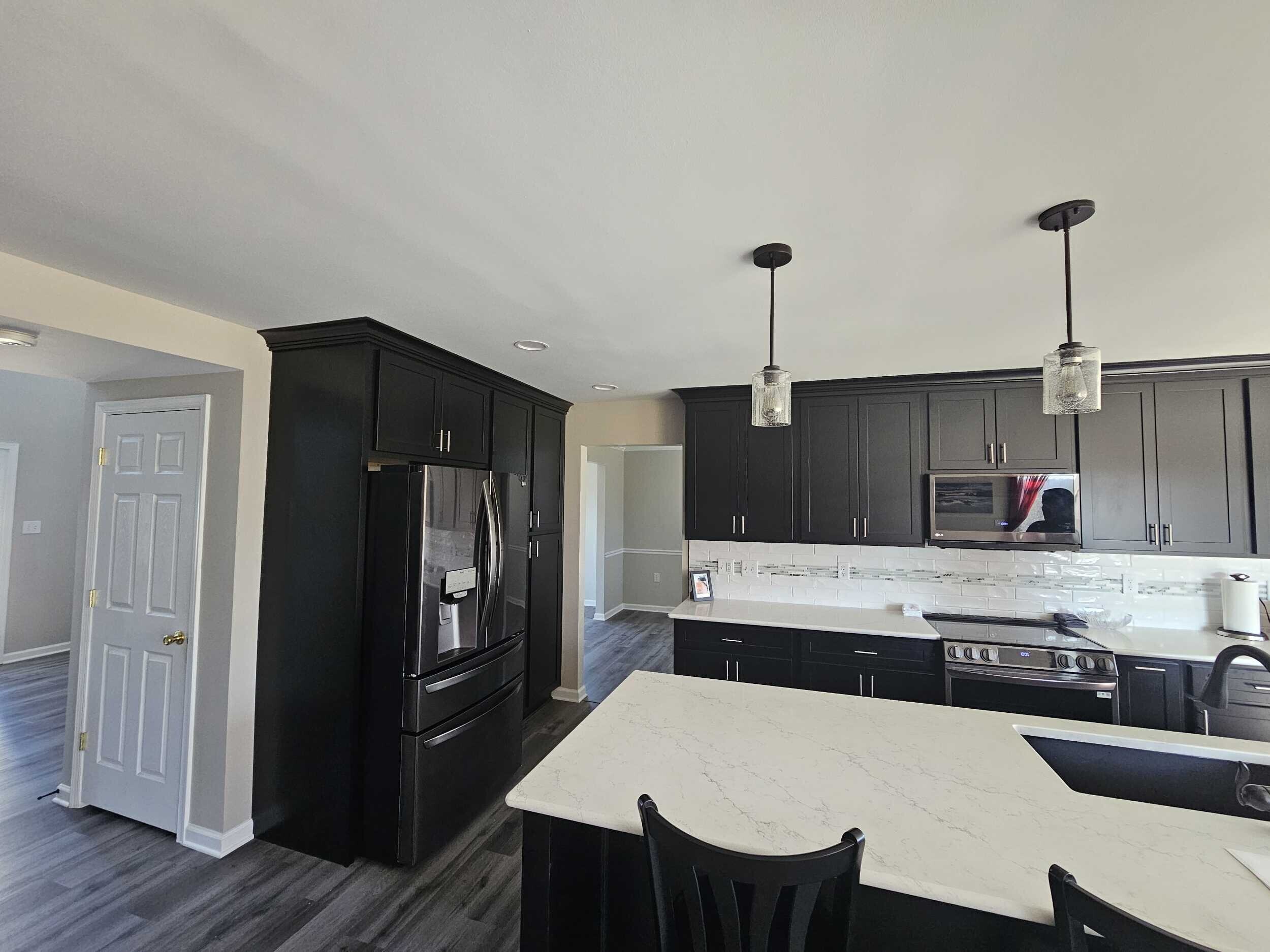 A contemporary kitchen with a fresh design, boasting glossy gray cabinets, quartz countertops, and a chic mosaic tile backsplash.