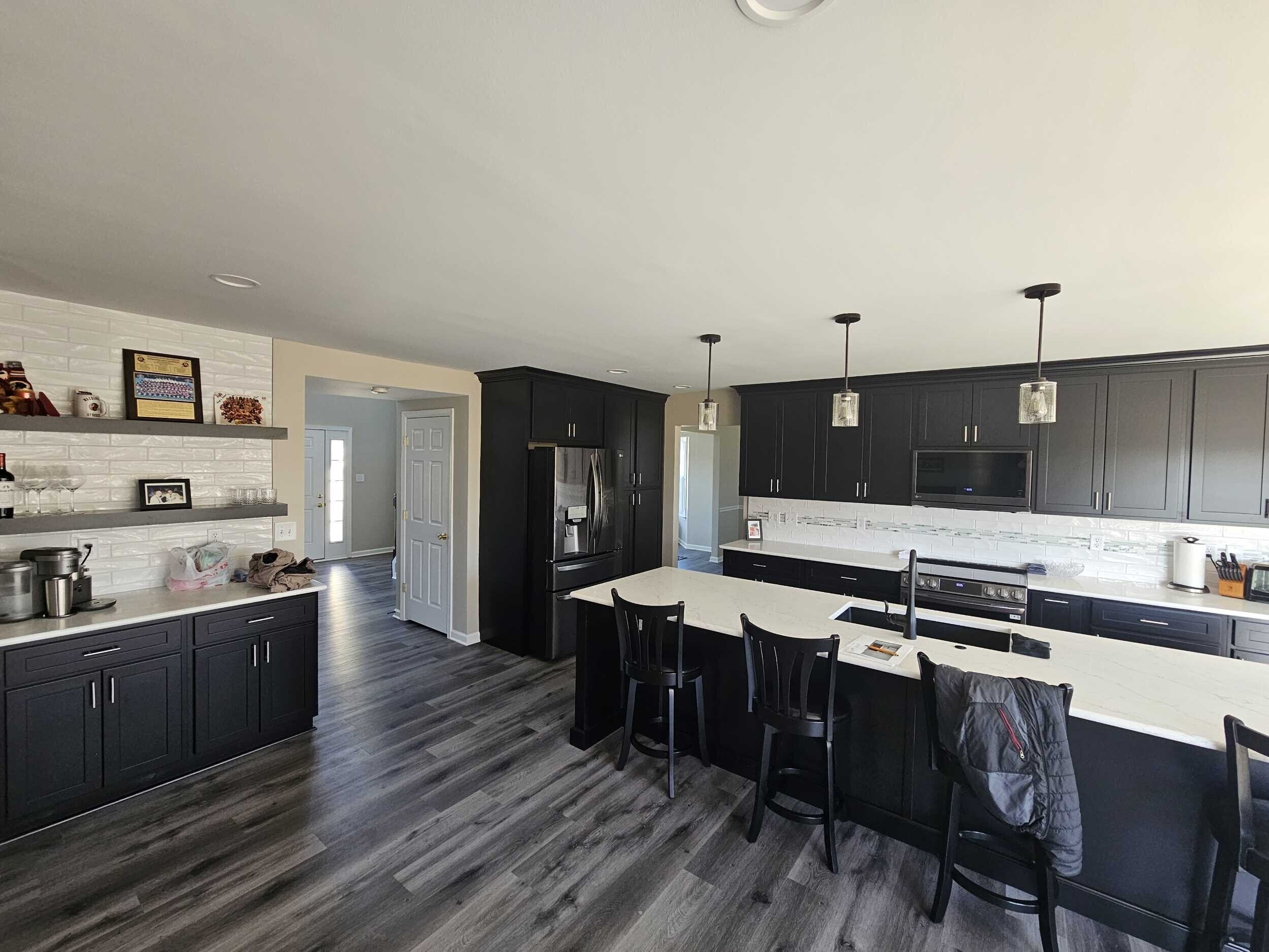A contemporary kitchen with a fresh design, boasting glossy gray cabinets, quartz countertops, and a chic mosaic tile backsplash.