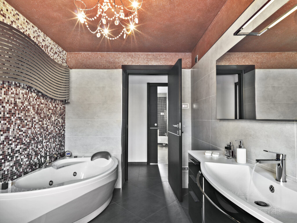 interiors of a modern bathroom to the left side the bathtub whie to the tight side the sink cabinet with inegrated washbasin above it there is a mirror