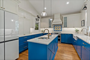 blue kitchen cabinets with hardwood flooring and island