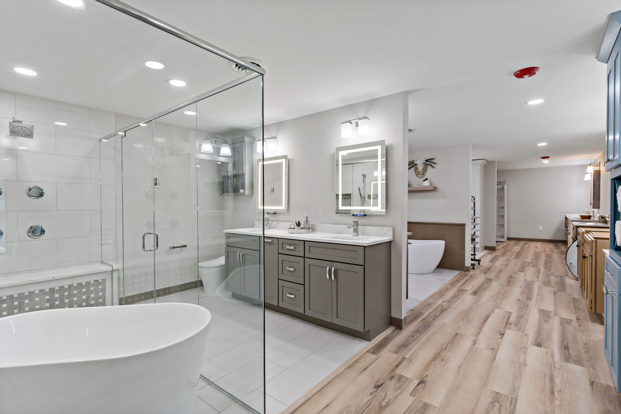 Showroom bathroom display with a freestanding tub and frameless glass shower