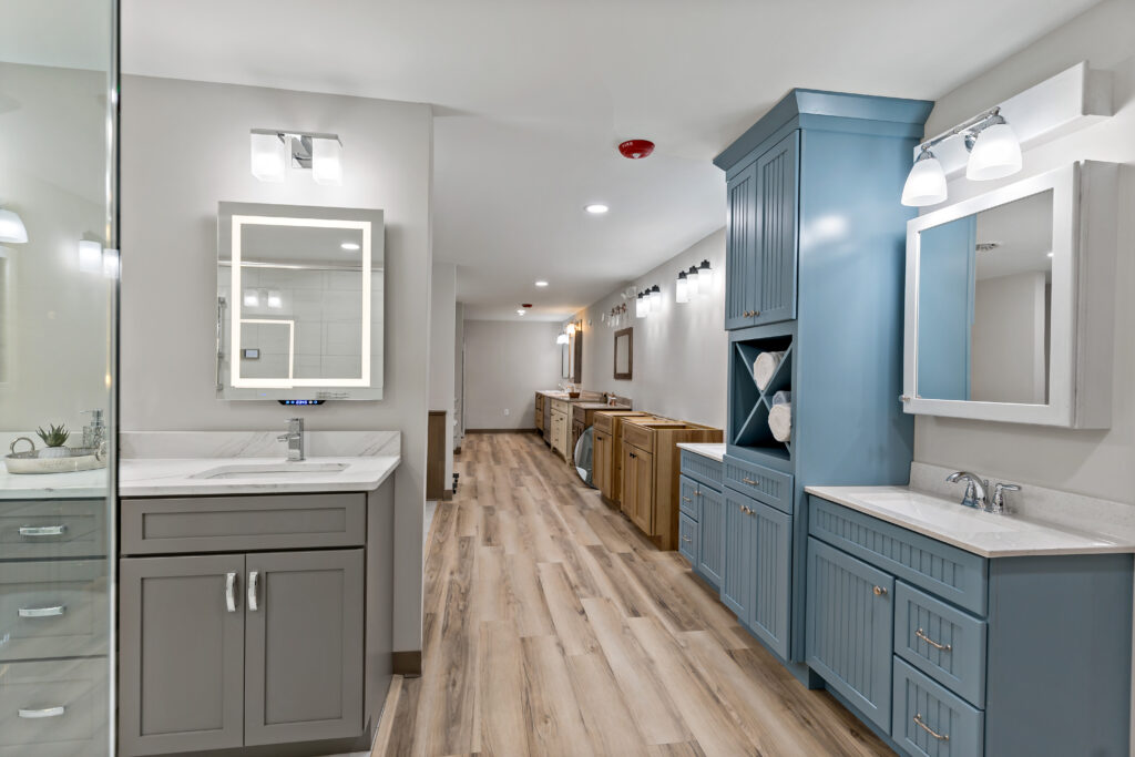 Showroom bath displays with lit mirrors and blue and grey vanities