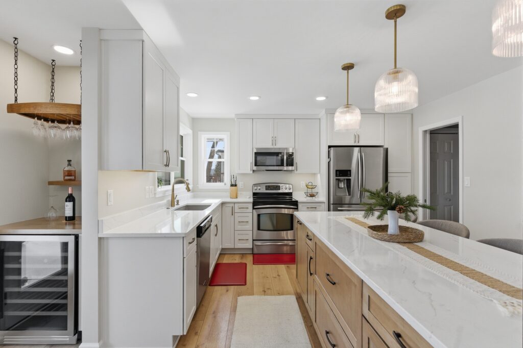 Bright white kitchen with a long quartz island and glass pendant lights