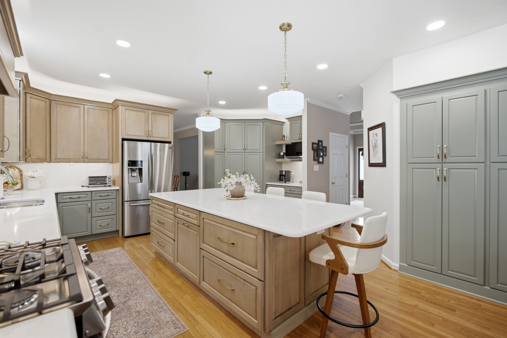 Kitchen with sage green cabinetry and a natural wood island