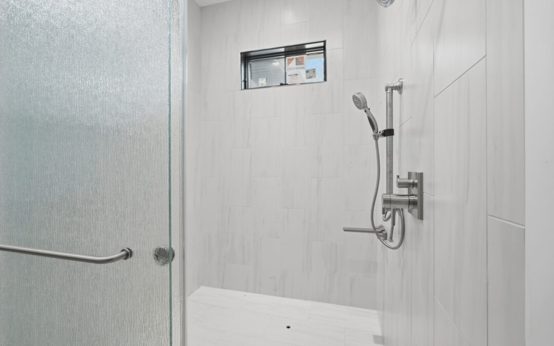 A modern tiled walk-in shower with a glass door, dual showerheads, and a small window.
